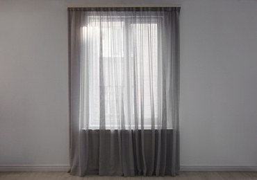 Photo of Window with beautiful curtains in empty room