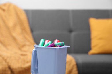 Mini recycling bin with different types of batteries indoors, closeup