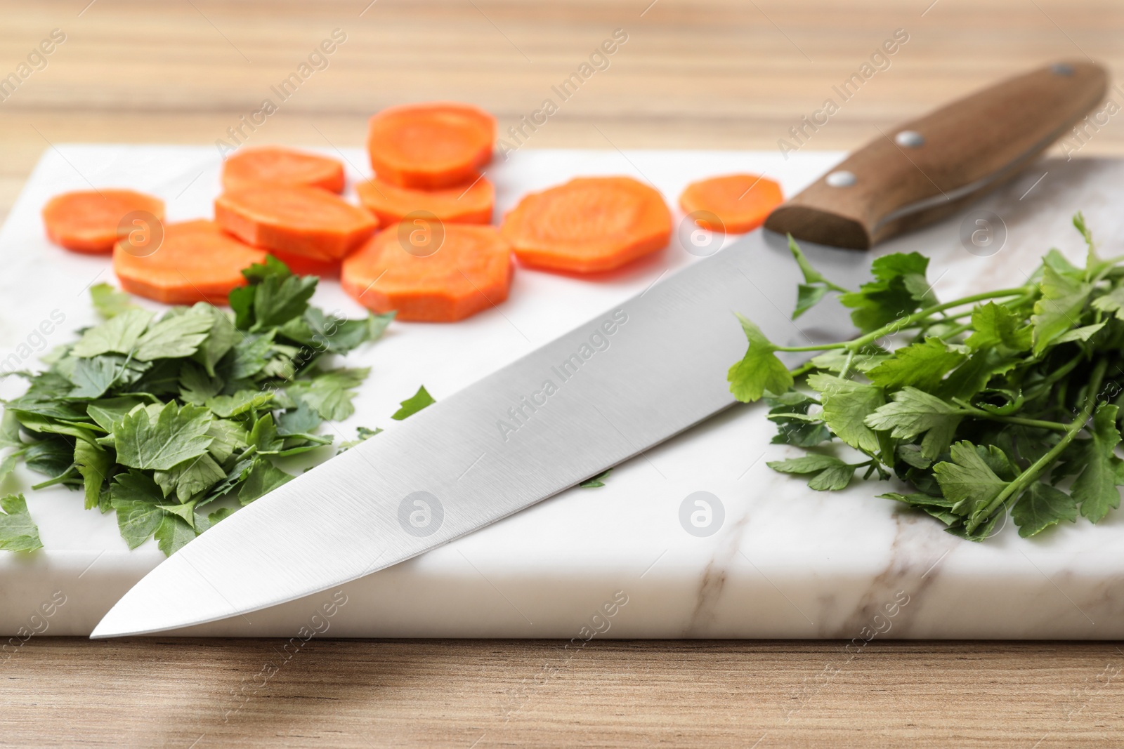Photo of Board with sharp knife and cut products on table, closeup