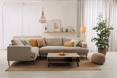 Stylish living room interior with comfortable grey sofa and coffee table