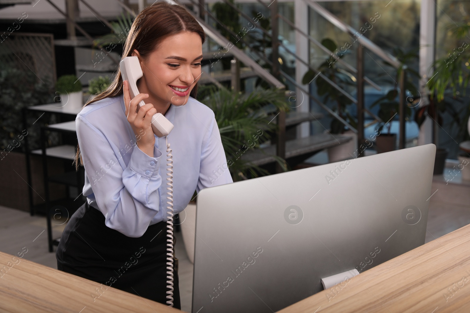 Photo of Female receptionist talking on phone at workplace