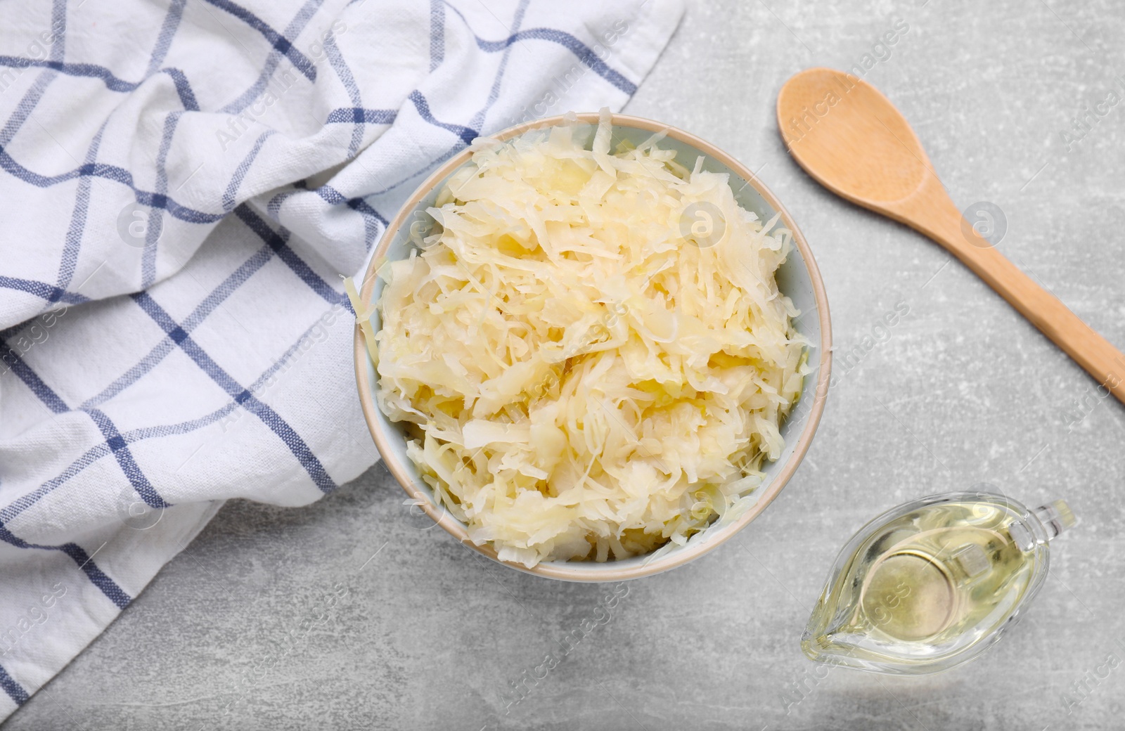 Photo of Bowl of tasty sauerkraut on grey table, flat lay