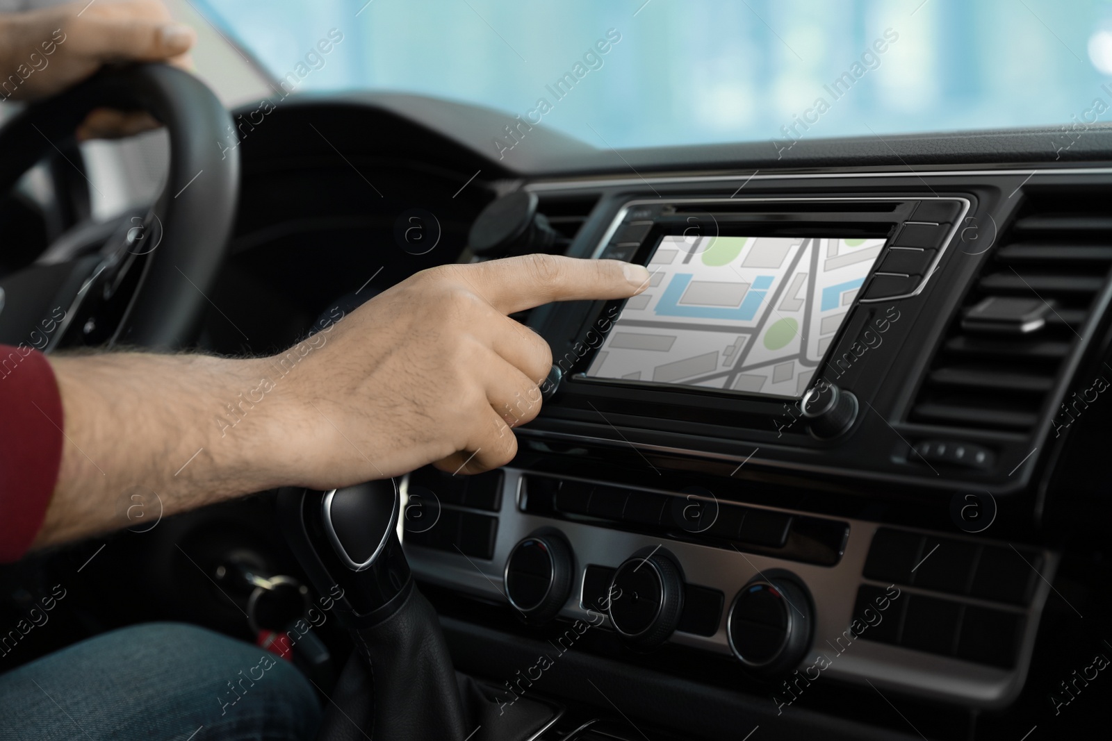 Image of Man using navigation system while driving car, closeup