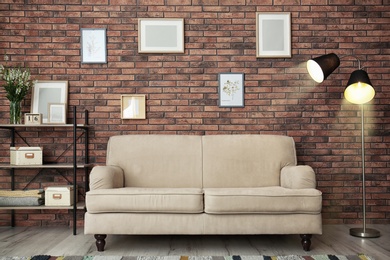 Photo of Modern living room interior with comfortable sofa near brick wall