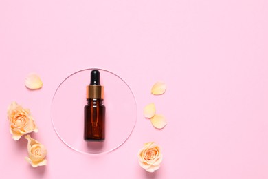 Photo of Bottle of cosmetic serum, flowers and petals on pink background, flat lay. Space for text