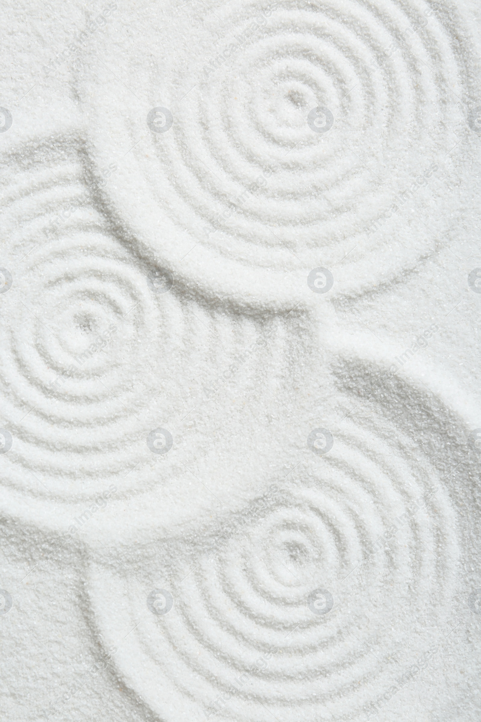 Photo of Zen rock garden. Circle patterns on white sand, top view