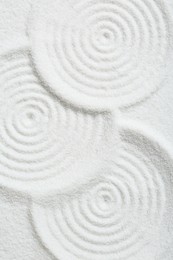 Photo of Zen rock garden. Circle patterns on white sand, top view