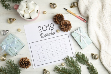 Photo of Flat lay composition with paper calendar on white wooden table