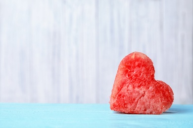 Photo of Heart shaped watermelon slice on table against light background