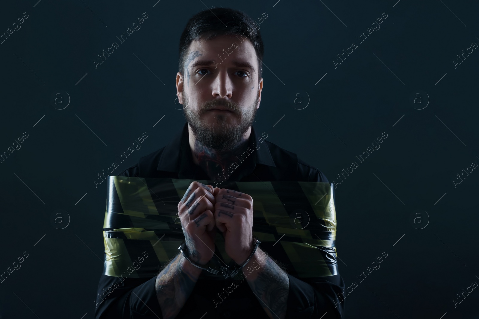 Photo of Man taped up and taken hostage on dark background