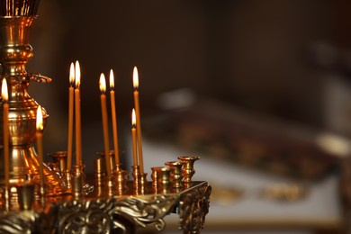 Photo of Burning candles on stand in church, closeup with space for text. Baptism ceremony