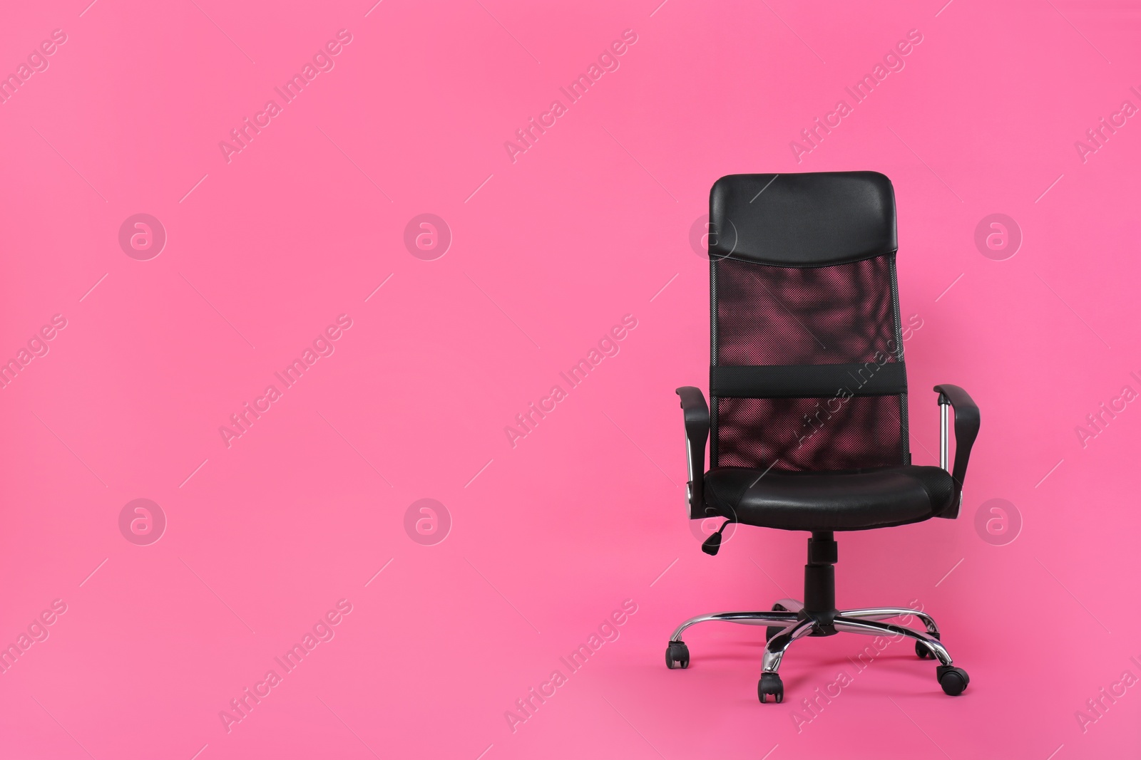 Photo of Comfortable office chair on pink background, space for text