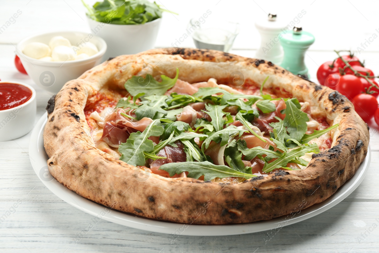 Photo of Tasty pizza with meat and arugula on white wooden table, closeup