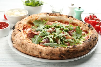 Tasty pizza with meat and arugula on white wooden table, closeup