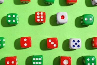 Photo of Many color game dices on green background, flat lay