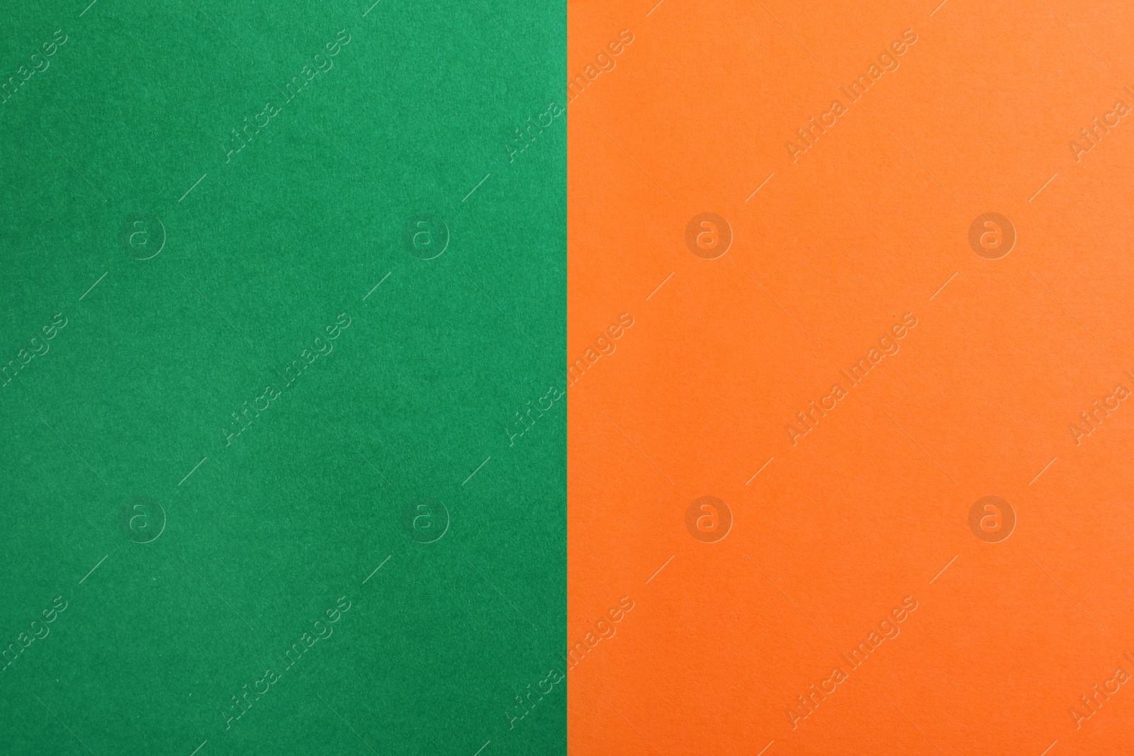 Photo of Green and orange paper sheets as colorful background, top view