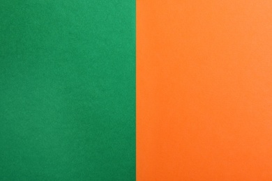 Photo of Green and orange paper sheets as colorful background, top view