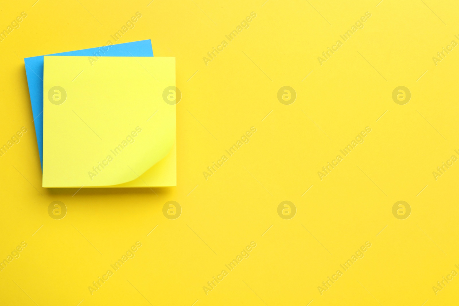 Photo of Paper notes on yellow background, top view. Space for text