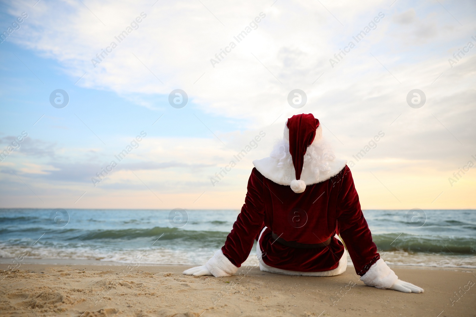 Photo of Santa Claus relaxing on beach, space for text. Christmas vacation