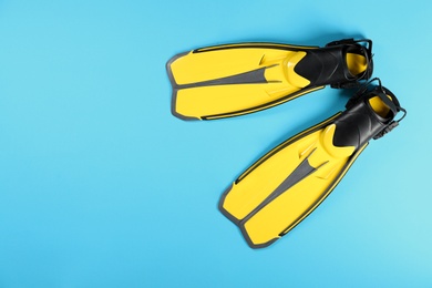 Photo of Swimming flippers on color background, top view. Space for text