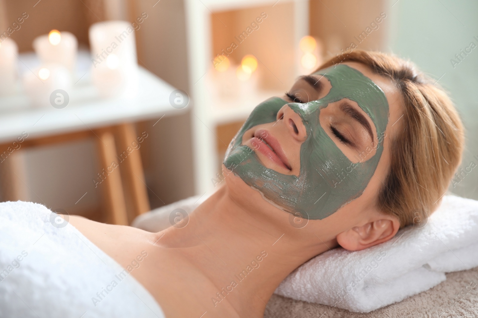 Photo of Beautiful woman with mask on face relaxing in spa salon