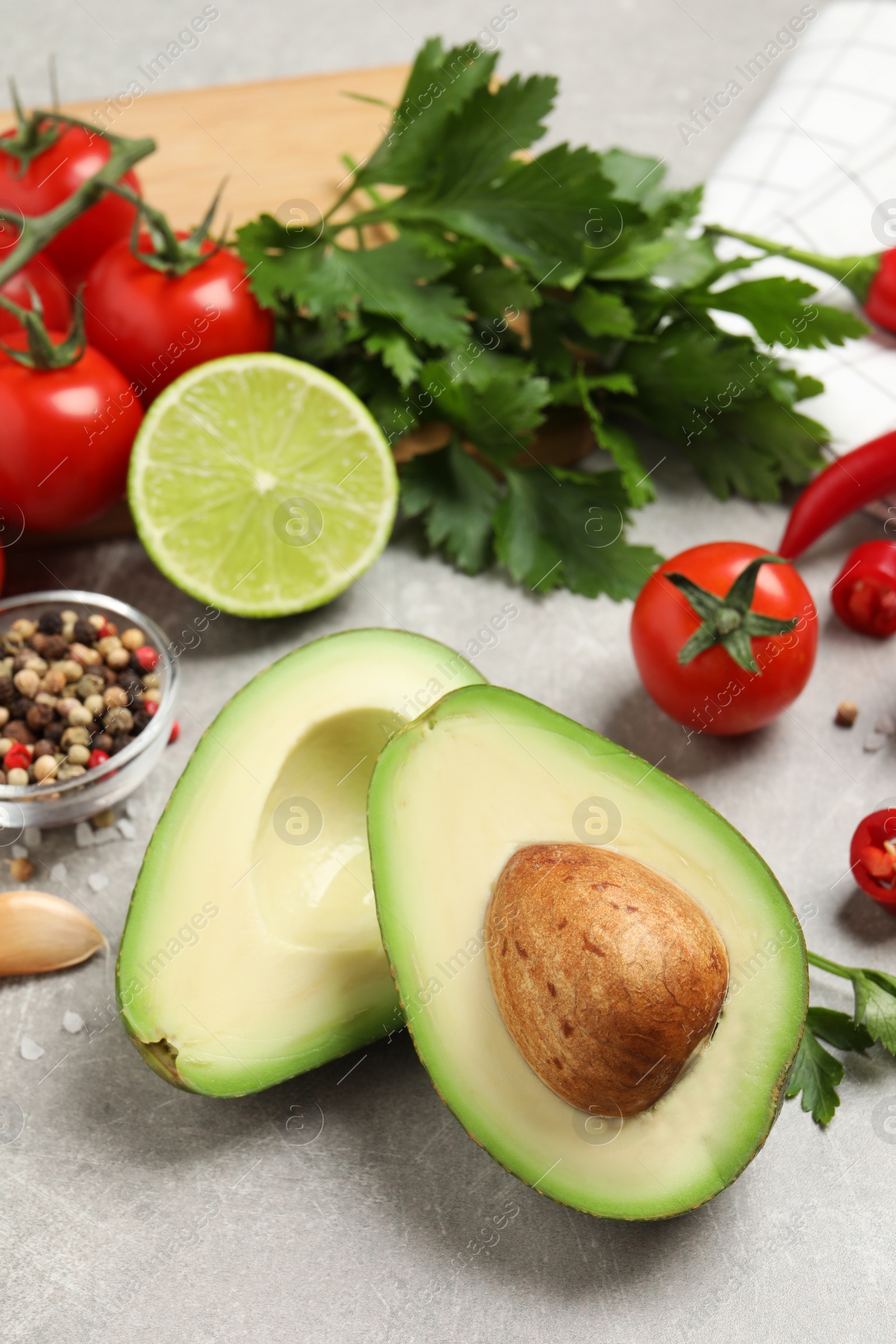 Photo of Fresh ingredients for guacamole on light grey table