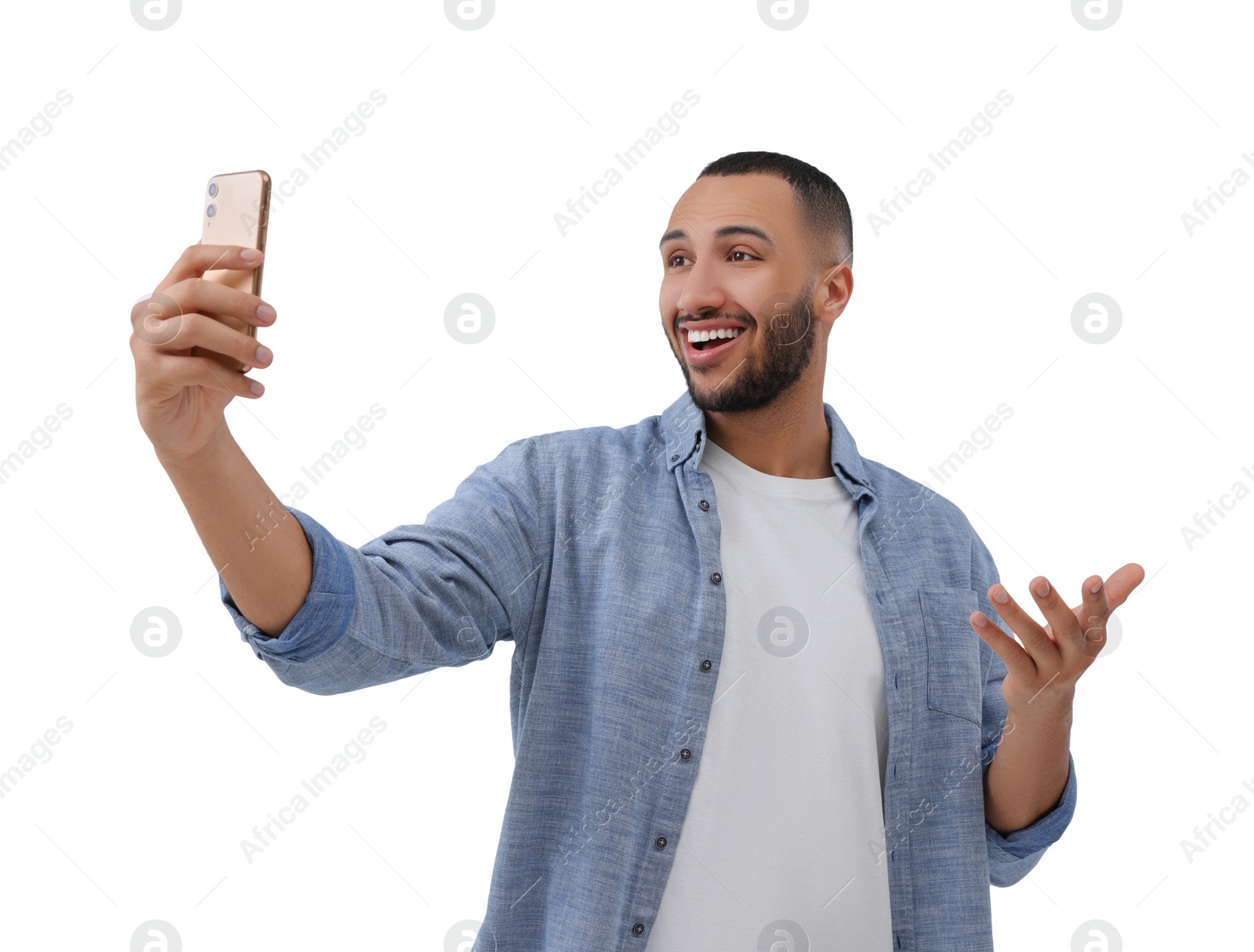 Photo of Smiling young man taking selfie with smartphone on white background