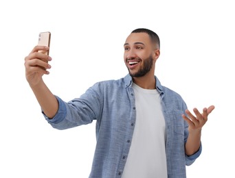 Photo of Smiling young man taking selfie with smartphone on white background