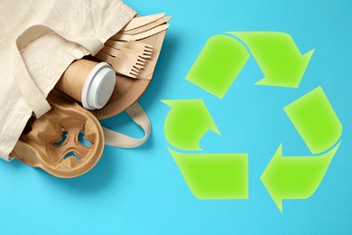 Image of Paper and wooden tableware in cotton bag and recycling symbol on turquoise background, top view