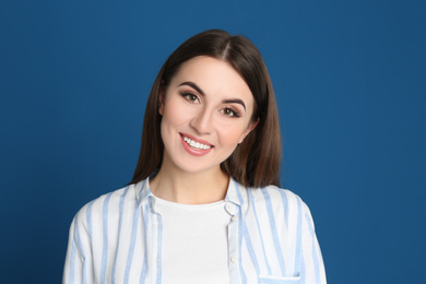 Photo of Portrait of happy young woman on blue background