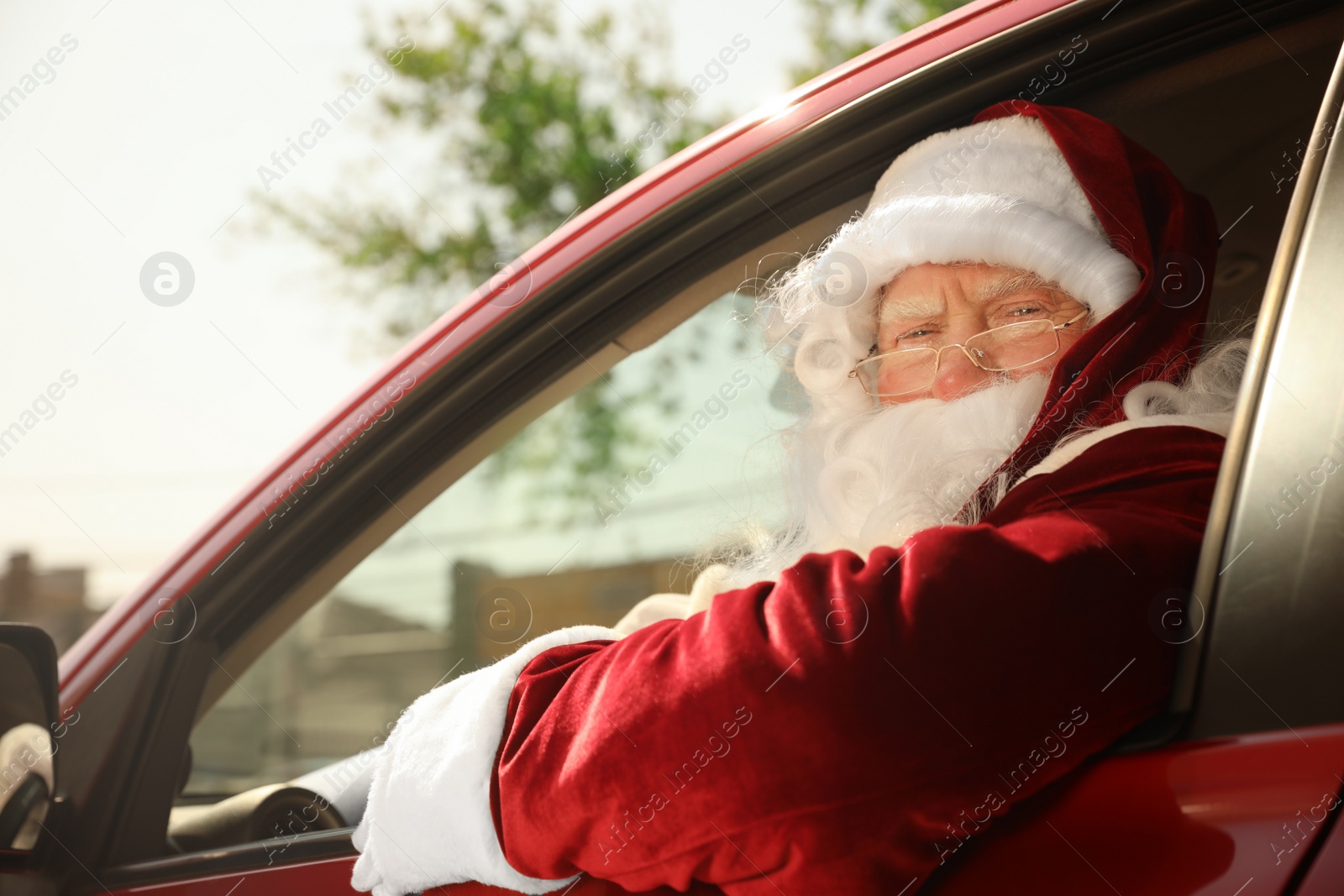 Photo of Authentic Santa Claus driving his modern car, outdoors