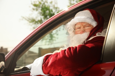 Photo of Authentic Santa Claus driving his modern car, outdoors
