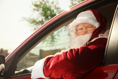 Authentic Santa Claus driving his modern car, outdoors