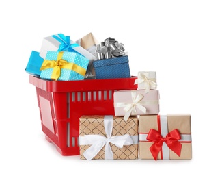 Photo of Red shopping basket with different gifts on white background