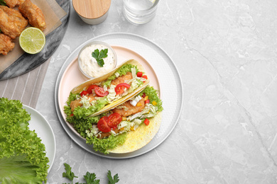 Photo of Delicious fish tacos served on grey marble table, flat lay with space for text