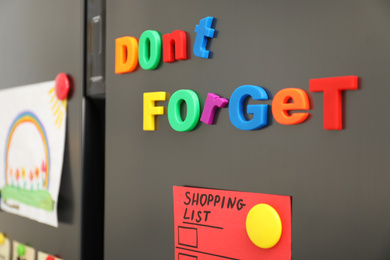 Photo of Phrase DON'T FORGET made of magnets on refrigerator door, closeup