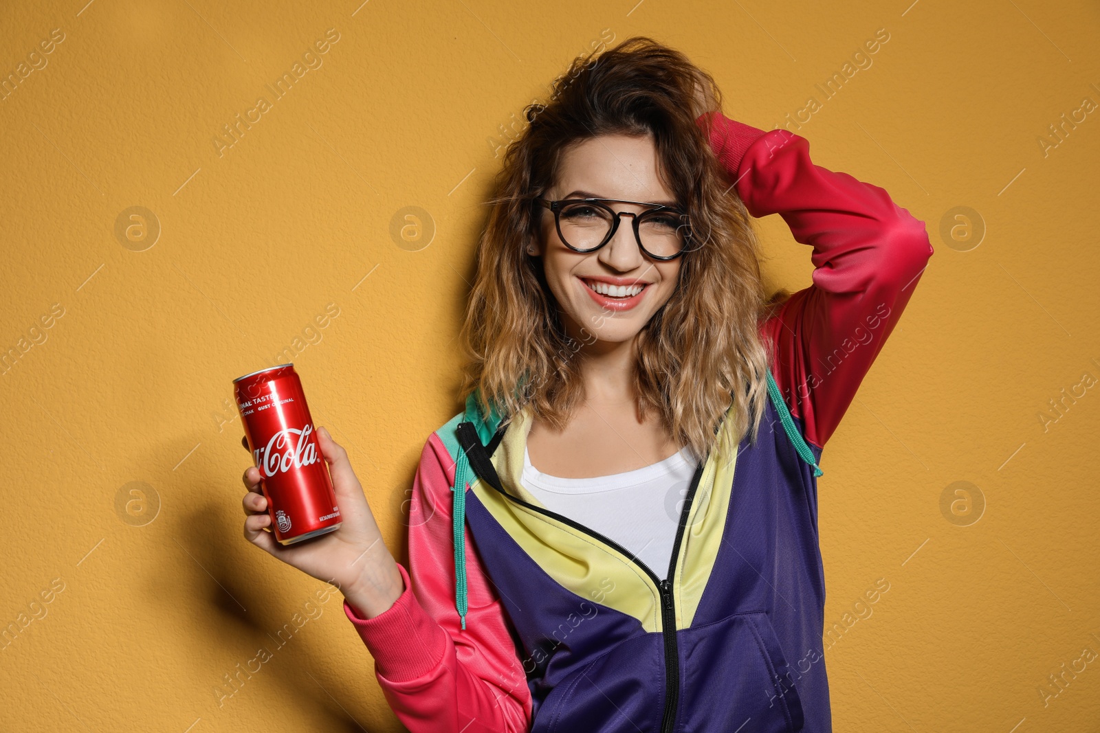 Photo of MYKOLAIV, UKRAINE - NOVEMBER 28, 2018: Young woman with Coca-Cola can on color background