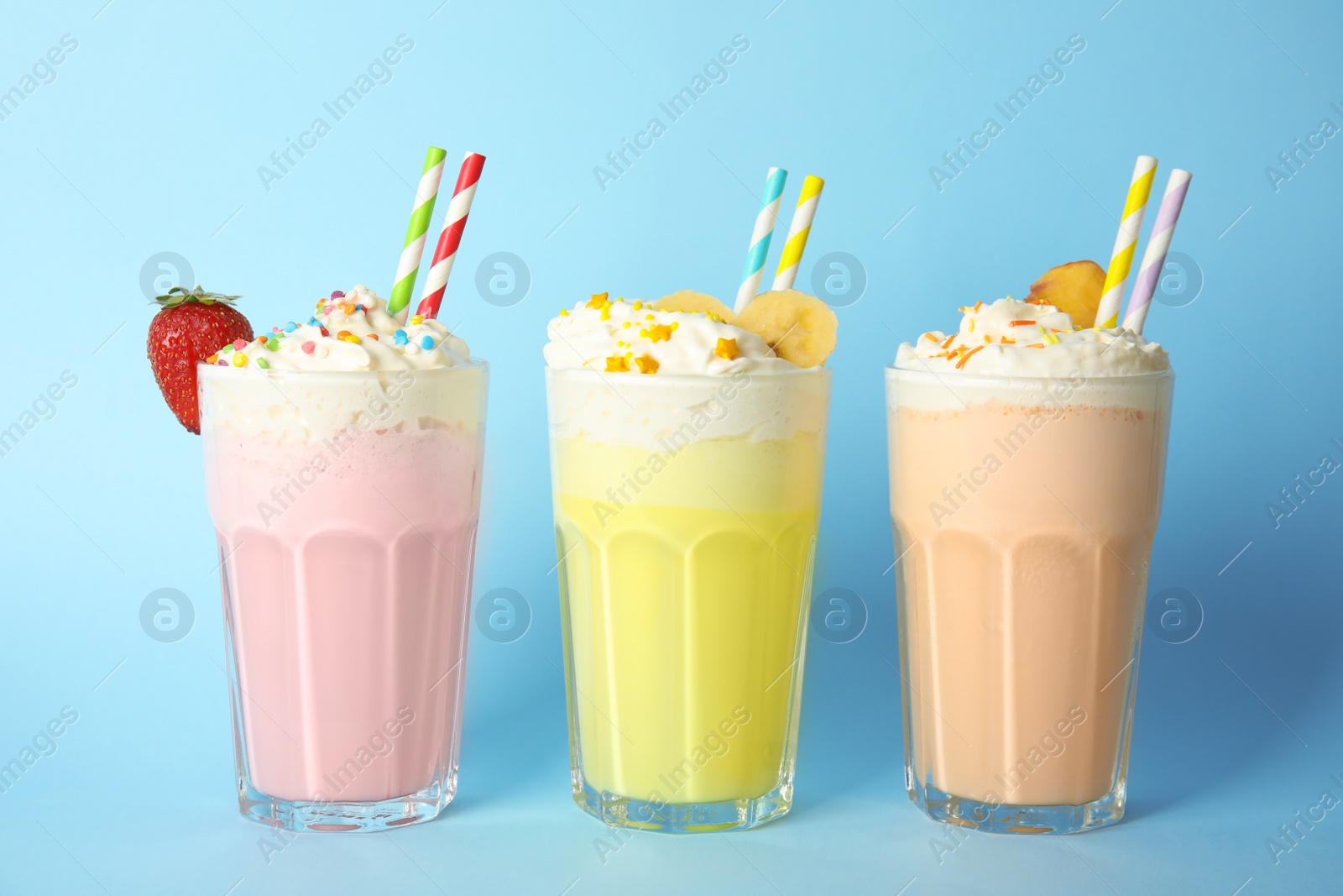 Photo of Glasses of tasty milk shakes on color background