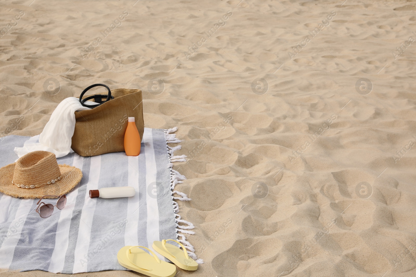 Photo of Bag and other beach items on sand, space for text
