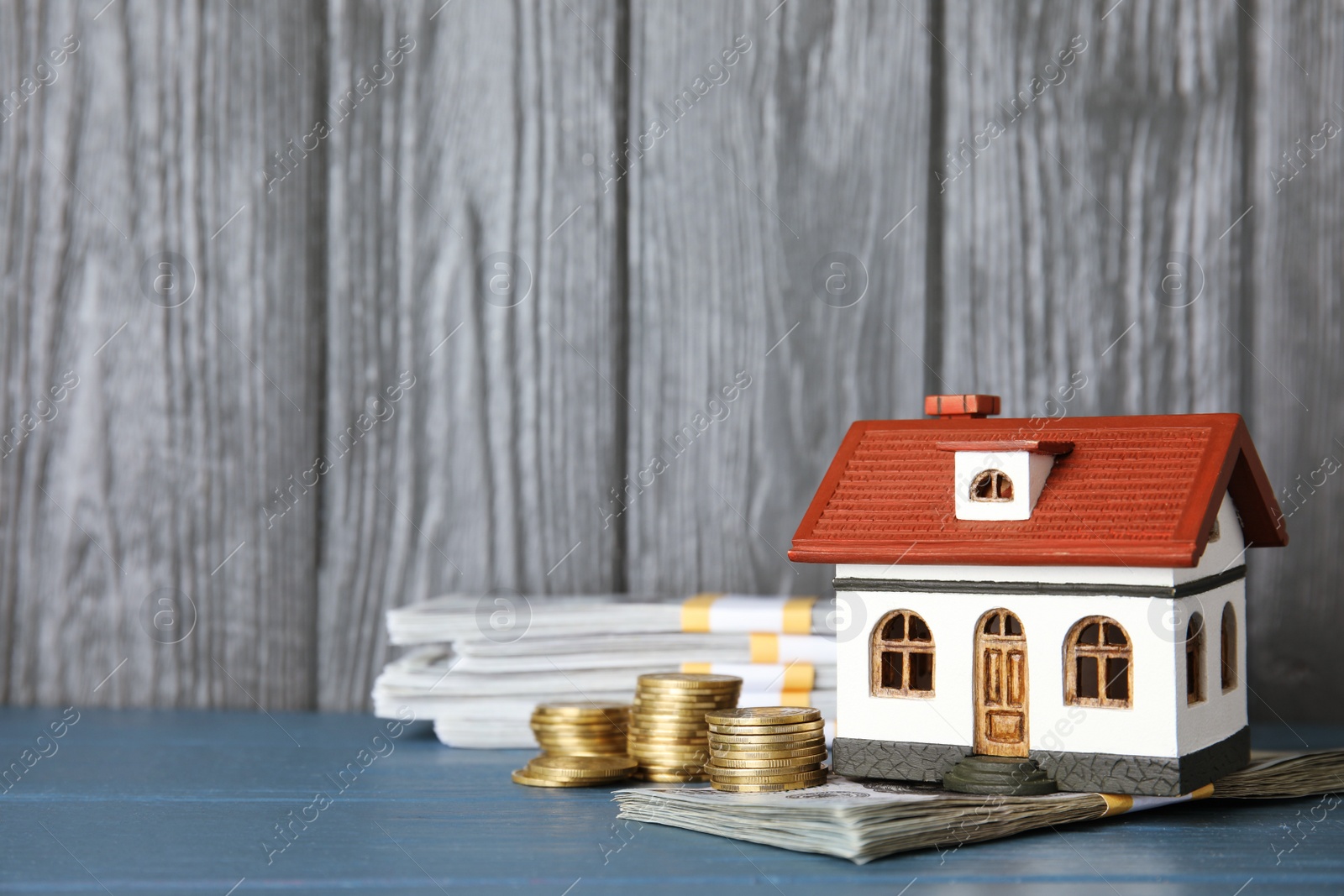 Photo of House model with money and space for text against wooden background