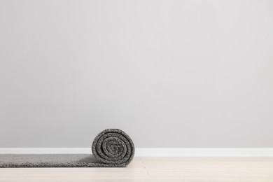 Photo of Rolled grey carpet on floor in room. Space for text