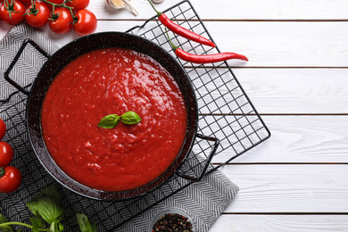 Delicious tomato sauce on white wooden table, flat lay. Space for text