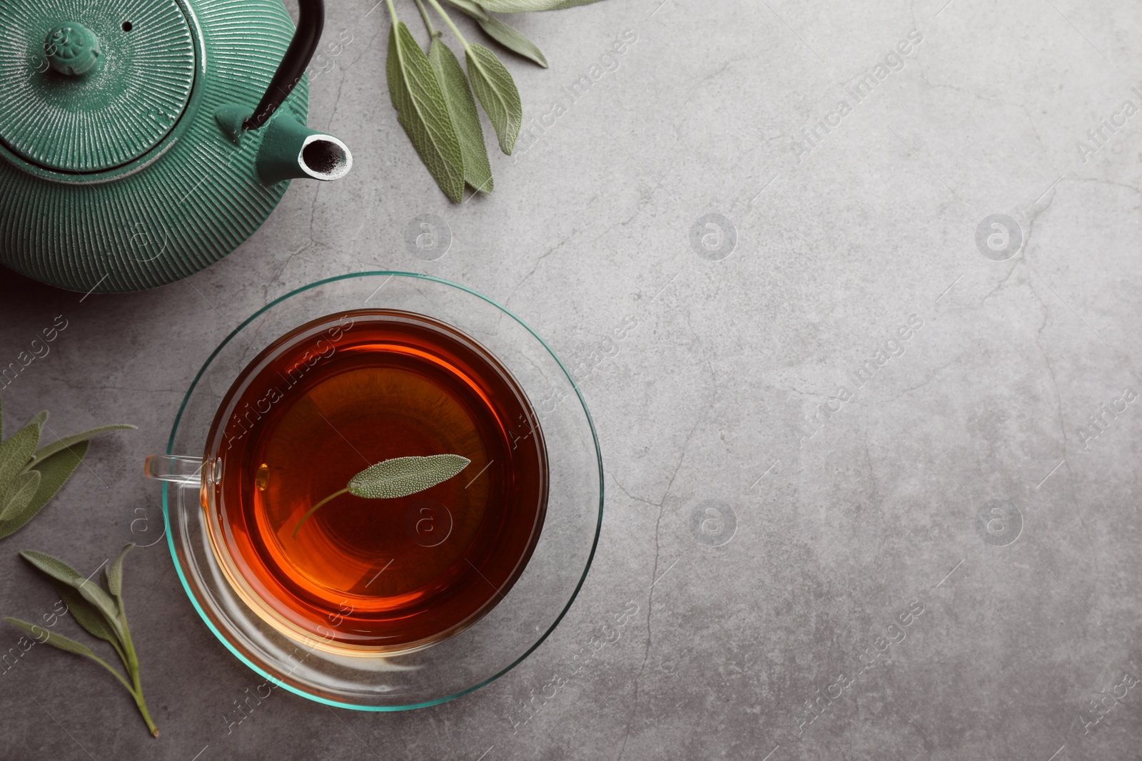 Photo of Aromatic herbal tea with sage on grey table, flat lay. Space for text