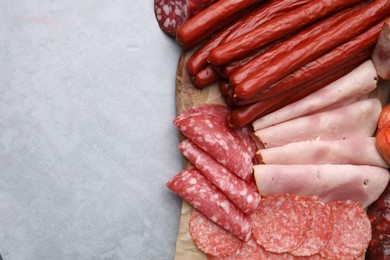 Photo of Different types of sausages on light grey table, flat lay. Space for text