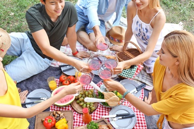 Photo of Happy friends having picnic in park on sunny day, closeup