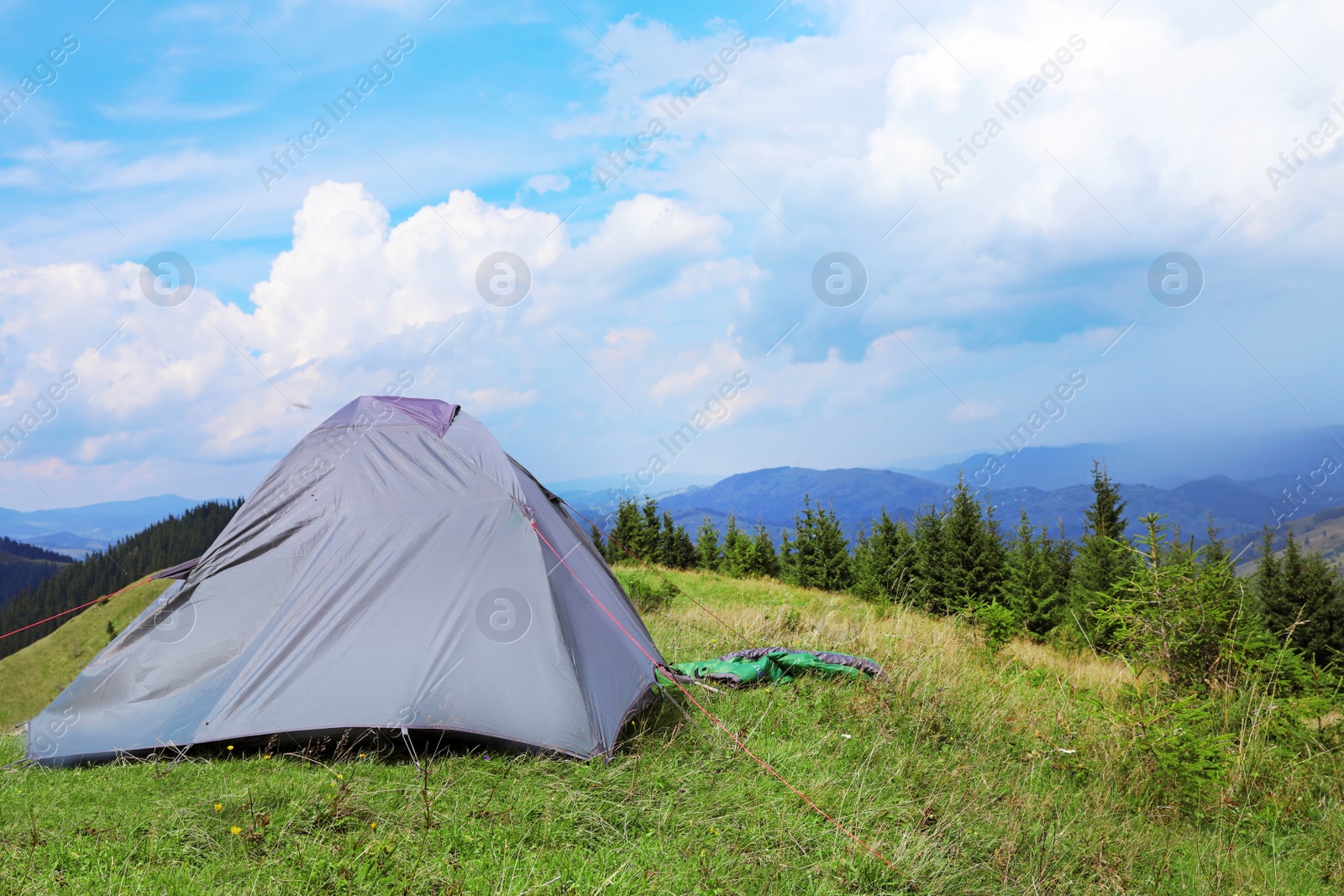 Photo of Small camping tent in mountains on sunny day