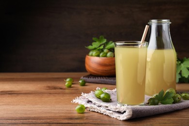 Tasty gooseberry juice on wooden table. Space for text