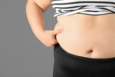 Photo of Overweight woman on gray background, closeup view