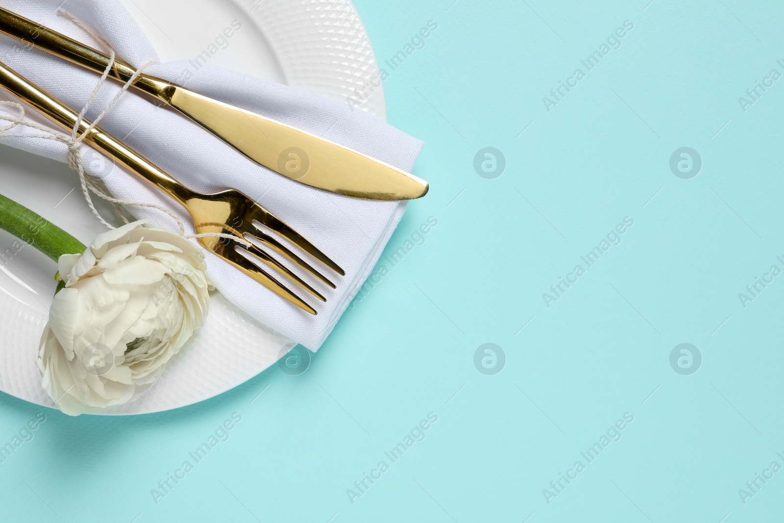 Photo of Stylish table setting with cutlery and flower on light blue background, top view. Space for text