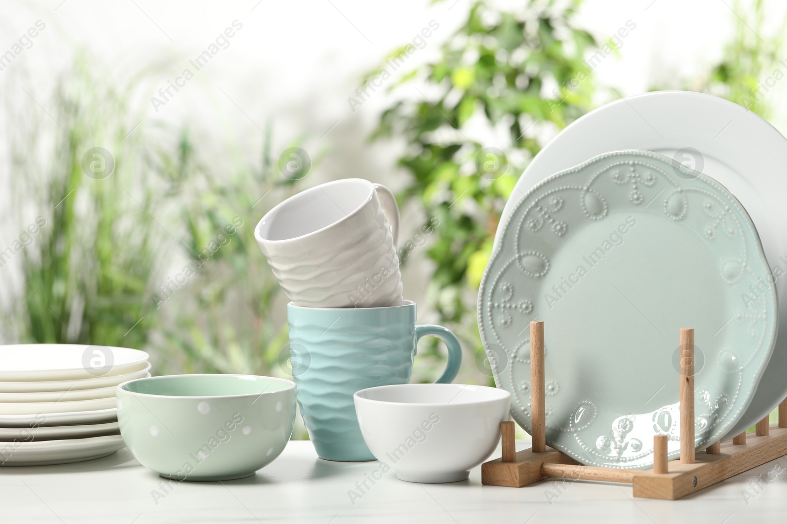 Photo of Beautiful ceramic dishware and cup on white table outdoors